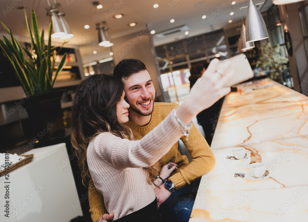 Young couple at the bar taking a selfie.