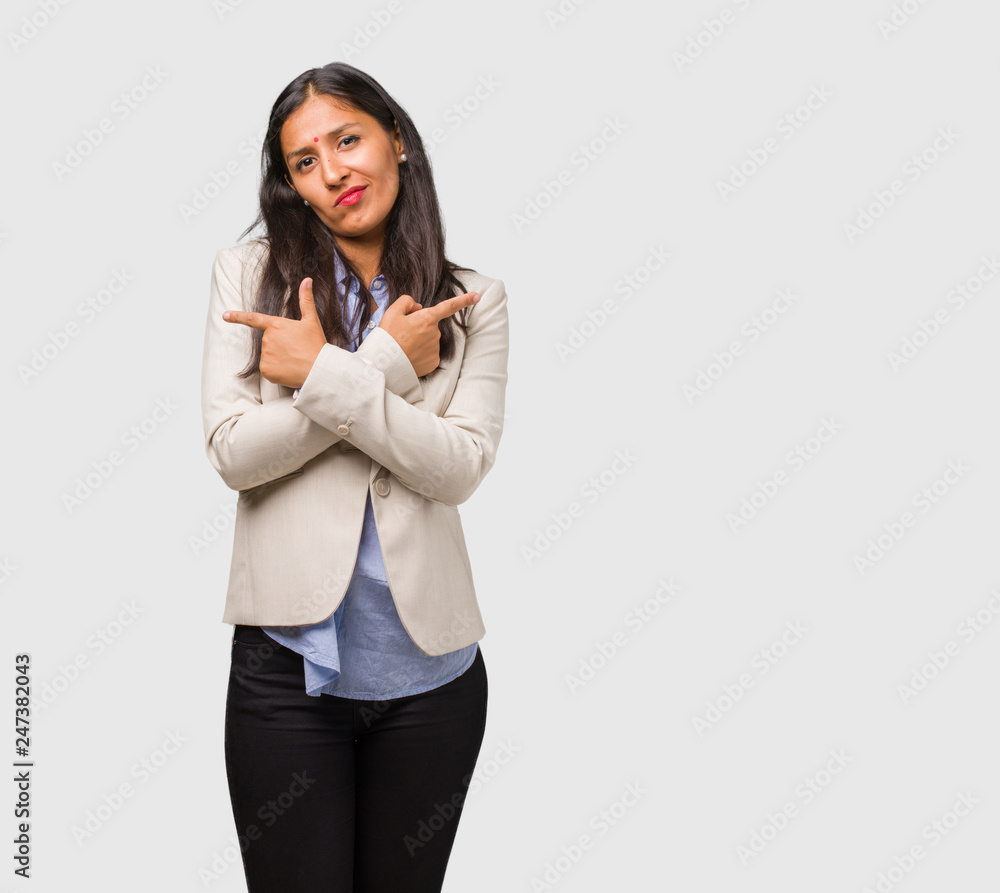 Young business indian woman confused and doubtful, decide between two options, concept of indecision Young business indian woman confused and doubtful, decide between two options, concept of indecision
