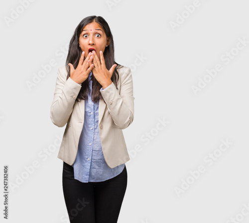 Young business indian woman surprised and shocked, looking with wide eyes, excited by an offer or by a new job, win concept