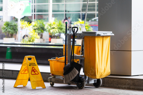 Janitorial and mop bucket on cleaning in process.