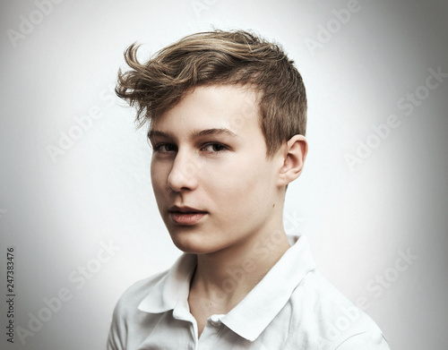 Portrait of a teenage boy blond on a white background close-up