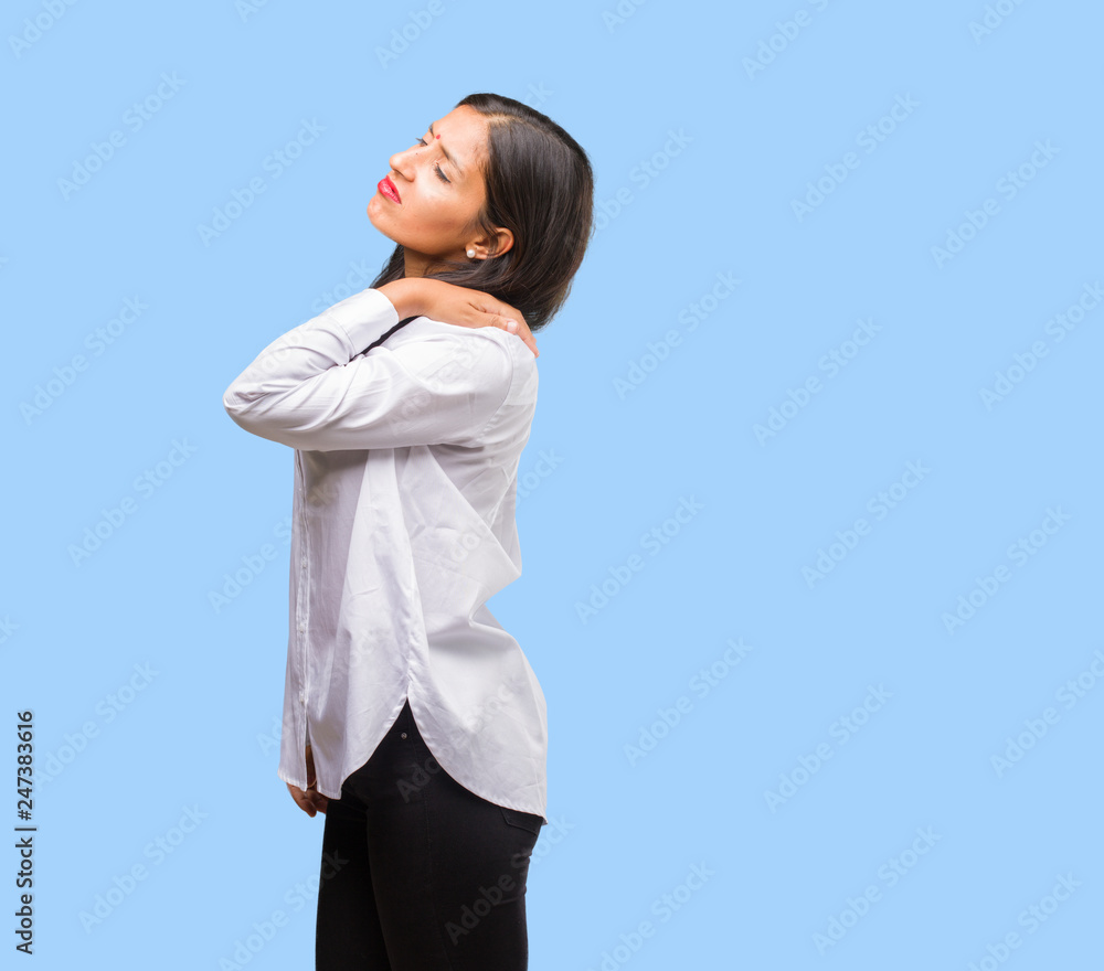 Portrait of a young indian woman with back pain due to work stress, tired and astute Portrait of a young indian woman with back pain due to work stress, tired and astute