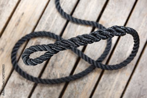 An eye splice in a piece of coiled rope on a wood background.