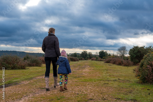 Mother and daughter on a foot path in New Forest countryside