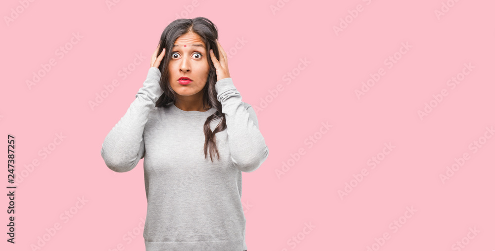 Fototapeta premium Portrait of young indian woman covering ears with hands, angry and tired of hearing some sound