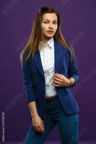 Portrait of a young girl in business suit isolated on a purple background.