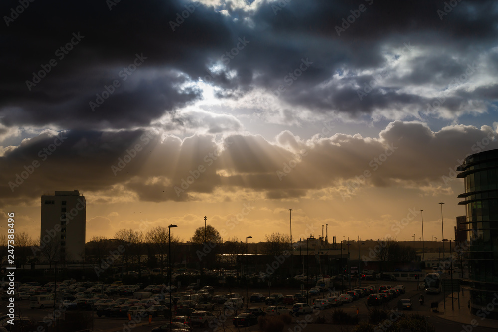 Dramatic sky with rays of sun over city