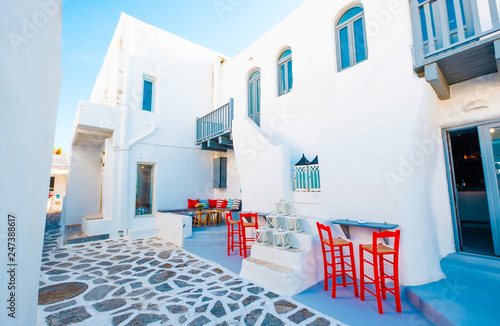 bright red chairs and sitting place inside of big building's courtyard on the greek street