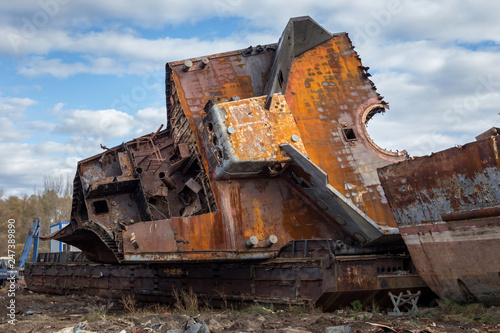 Huge rusty pieces of decommissioned marine ship that was cut and left on the shore. photo