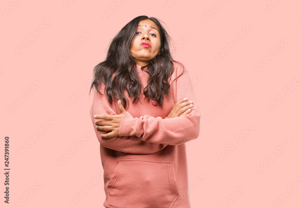Portrait of fitness young indian woman doubting and shrugging shoulders, concept of indecision and insecurity, uncertain about something Portrait of fitness young indian woman doubting and shrugging shoulders, concept of indecision and insecurity, uncertain about something