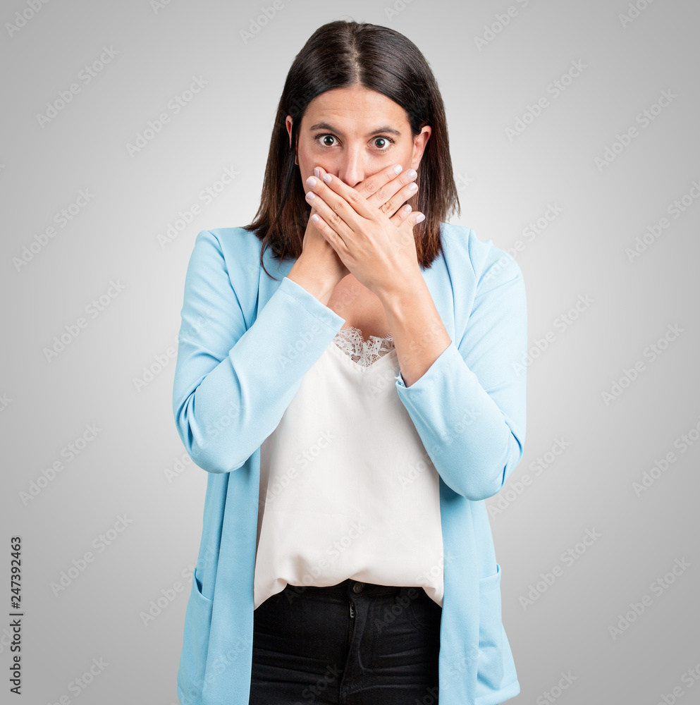 Middle aged woman covering mouth, symbol of silence and repression, trying not to say anything Middle aged woman covering mouth, symbol of silence and repression, trying not to say anything