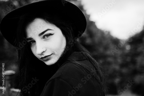 Sensual girl all in black, red lips and hat. Goth dramatic woman. Black and white portrait.