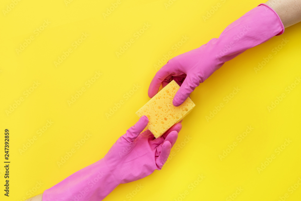Two women holding one sponge for washing in the hands Two women holding one sponge for washing in the hands