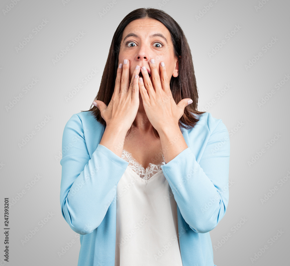 Middle aged woman surprised and shocked, looking with wide eyes, excited by an offer or by a new job, win concept Middle aged woman surprised and shocked, looking with wide eyes, excited by an offer or by a new job, win concept