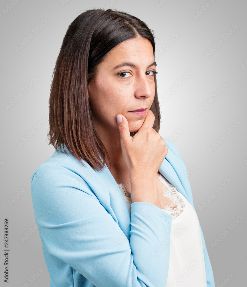 Middle aged woman thinking and looking up, confused about an idea, would be trying to find a solution Middle aged woman thinking and looking up, confused about an idea, would be trying to find a solution