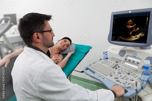 doctor watching the medical computer with a woman patient photo