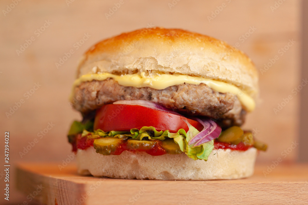 Tasty grilled prawn and beef burger with lettuce and mayonnaise served on pieces of brown paper on a rustic wooden table of counter, with copyspace Tasty grilled prawn and beef burger with lettuce and mayonnaise served on pieces of brown paper on a rustic wooden table of counter, with copyspace