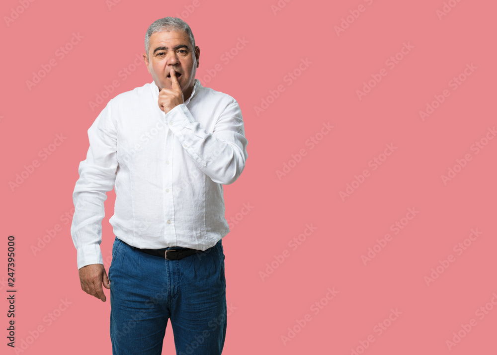 Middle aged man keeping a secret or asking for silence, serious face, obedience concept Middle aged man keeping a secret or asking for silence, serious face, obedience concept