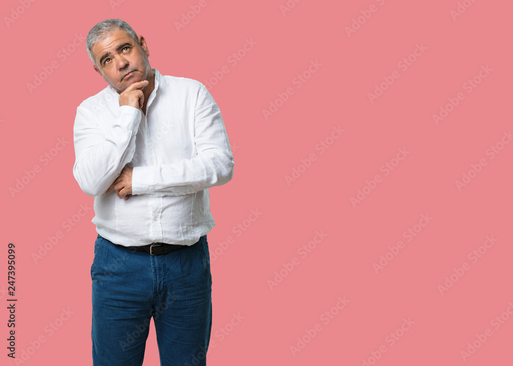 Middle aged man thinking and looking up, confused about an idea, would be trying to find a solution Middle aged man thinking and looking up, confused about an idea, would be trying to find a solution