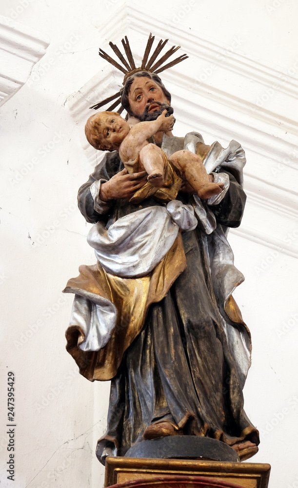 Fototapeta premium Statue of Saint Joseph with baby Jesus on the Saint Anthony altar in the church of Saint Leonard of Noblac in Kotari, Croatia