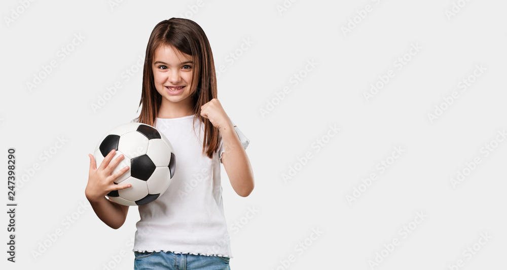 Full body little girl smiling and happy, holding a soccer ball, competitive attitude, excited to play a game Full body little girl smiling and happy, holding a soccer ball, competitive attitude, excited to play a game