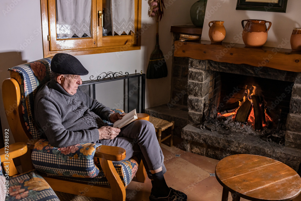 Relaxed senior man sitting in front of the fireplace