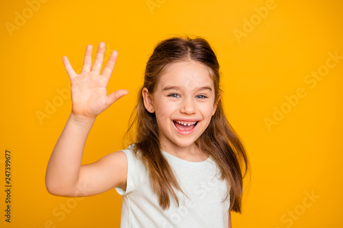 Portrait of her she nice-looking cute attractive lovely pretty cheerful cheery positive pre-teen girl waving hi hello greetings I'm here isolated over bright vivid shine yellow background