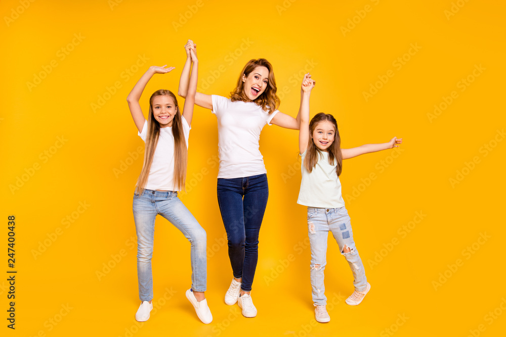 Full length body size view portrait of three nice cute attractive stylish healthy slim cheerful people holding raising hands mum mommy win winner isolated over bright vivid shine yellow background Full length body size view portrait of three nice cute attractive stylish healthy slim cheerful people holding raising hands mum mommy win winner isolated over bright vivid shine yellow background