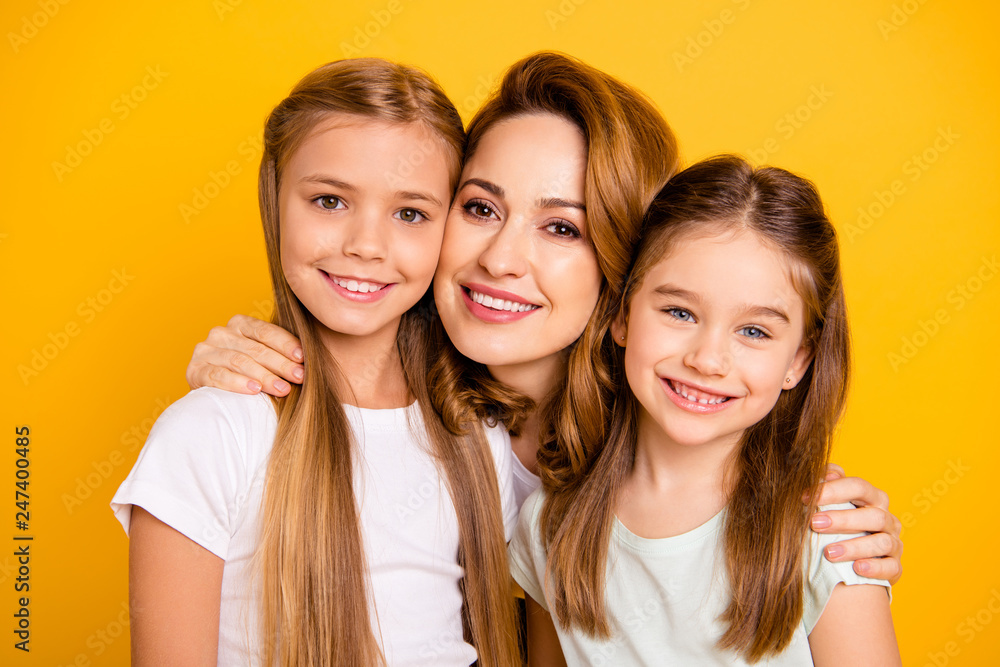 Close-up portrait of three nice cute adorable attractive healthy cheerful caucasian people cuddling mum mommy isolated over bright vivid shine yellow background Close-up portrait of three nice cute adorable attractive healthy cheerful caucasian people cuddling mum mommy isolated over bright vivid shine yellow background