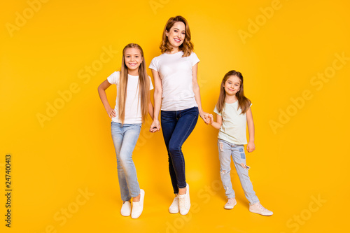 Full length body size view portrait of three nice cute attractive adorable stylish healthy slim cheerful people holding hands mum mommy isolated over bright vivid shine yellow background
