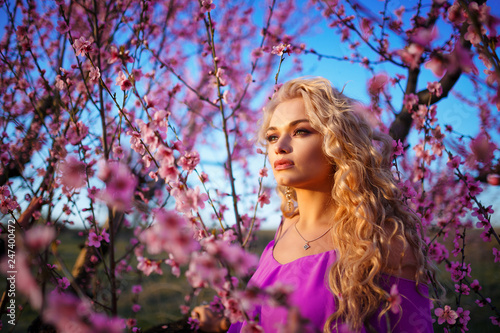 portrait of beautiful blonde woman in blooming rose garden, spring mood Sunny day