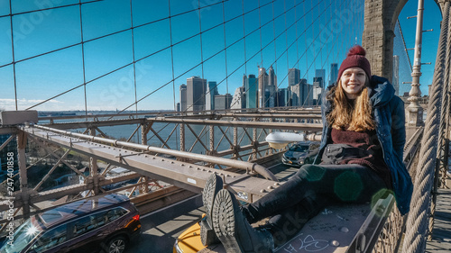 Young beautiful woman on Brooklyn Bridge New York enjoys a wonderful sunny day