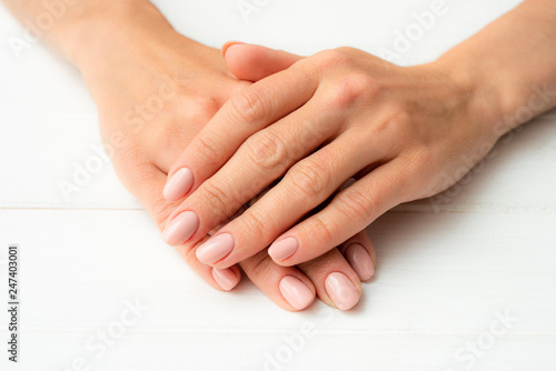 Woman's hands on a white wooden table