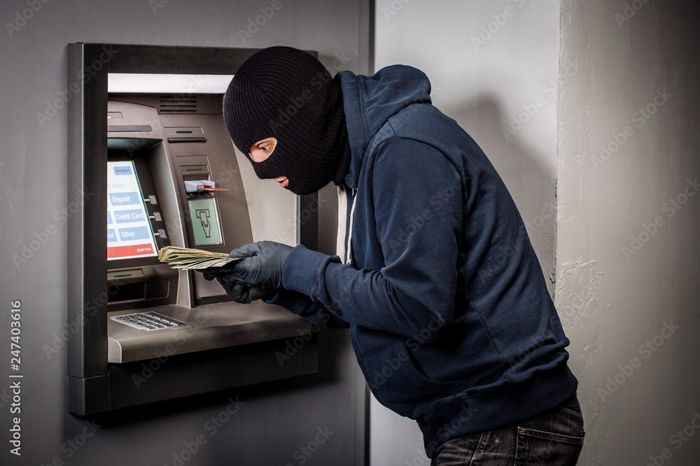 thief with crowbar opens the ATM.