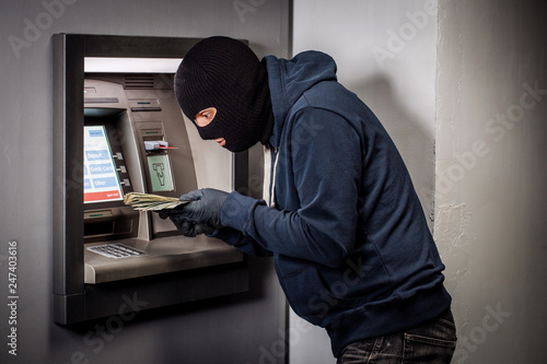 thief with crowbar opens the ATM.