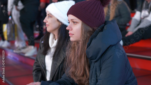 Two girls at Times Square by night sit on the famous red steps © 4kclips