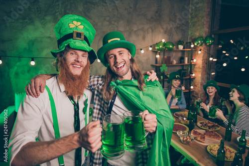 Portrait of two nice handsome attractive lovely stylish cheerful cheery glad positive optimistic guys group of people having fun brewery festive night life indoors pub