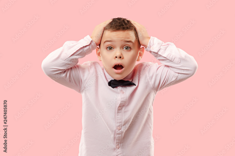 Wow. Attractive male half-length front portrait on pink studio backgroud. Young emotional surprised teen boy standing with open mouth. Human emotions, facial expression concept. Trendy colors Wow. Attractive male half-length front portrait on pink studio backgroud. Young emotional surprised teen boy standing with open mouth. Human emotions, facial expression concept. Trendy colors