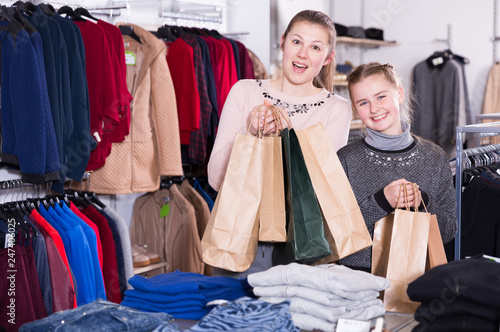 Mother and daughter with bags in clothes shop