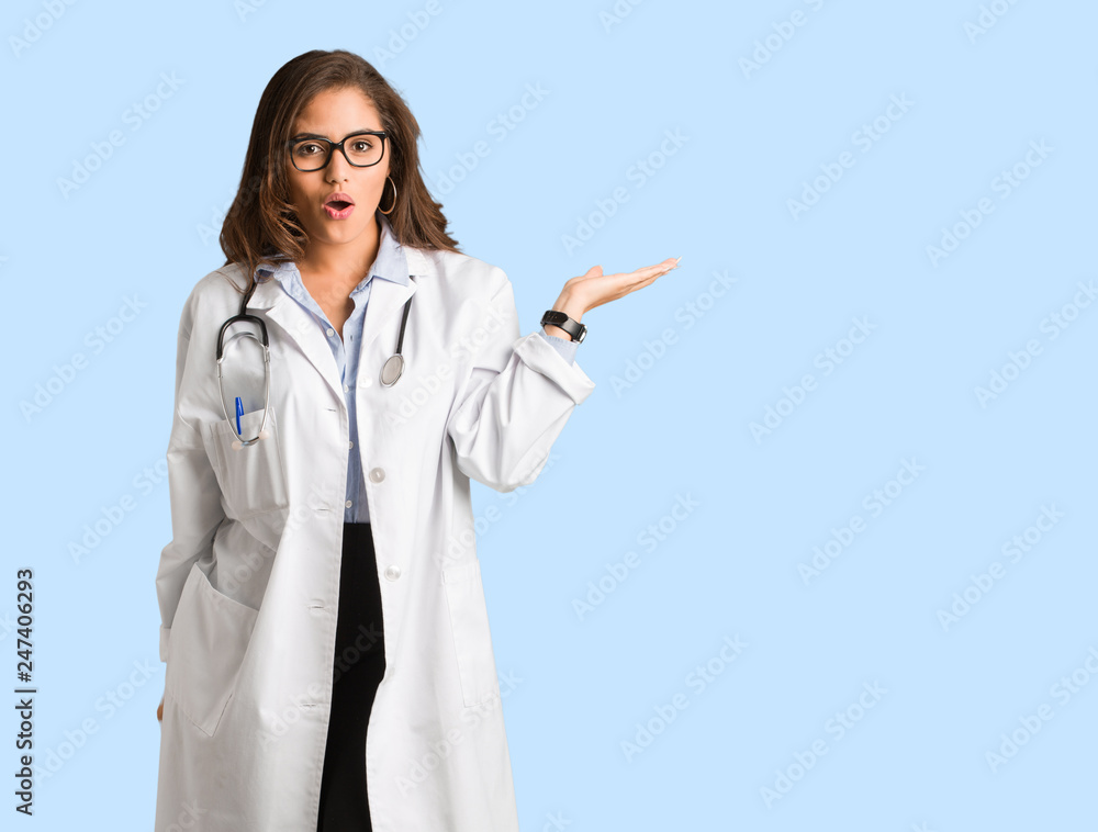Full body young doctor woman holding something on palm hand Full body young doctor woman holding something on palm hand