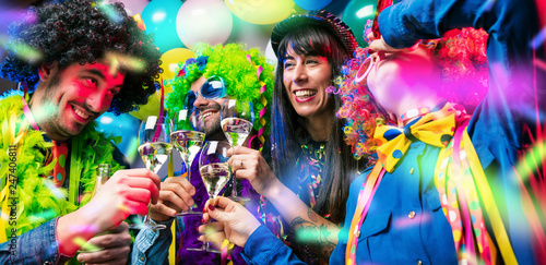 Lachende Freunde in bunten Kostümen trinken Sekt bei einer Karneval party .