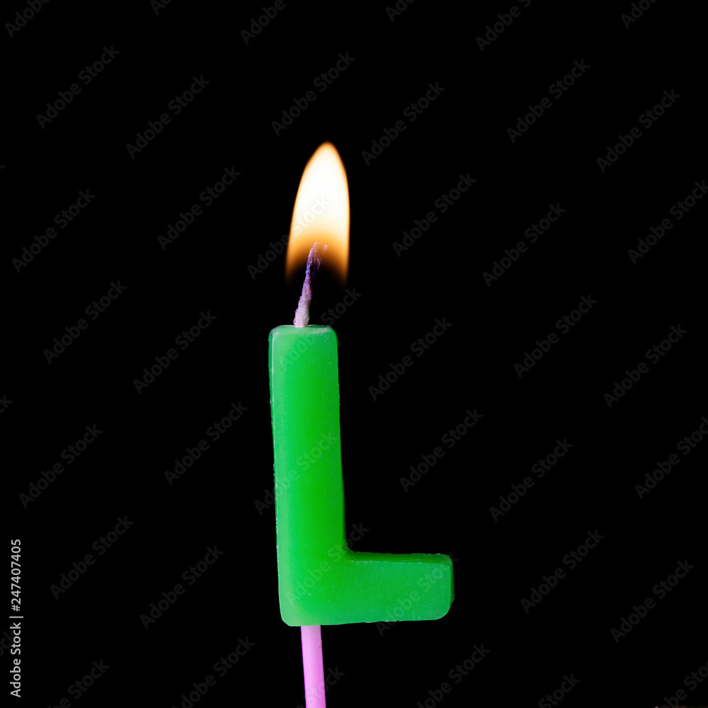 Letter L celebration birthday candle against a black background Letter L celebration birthday candle against a black background
