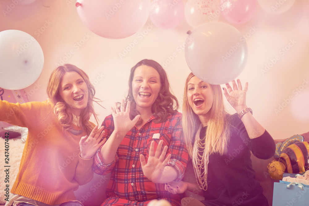 Pregnant woman celebrating baby shower party with friends.