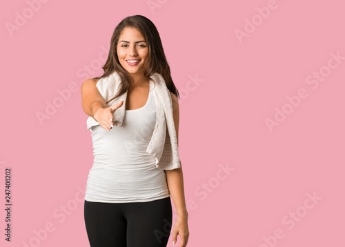 Full body young fitness curvy woman reaching out to greet someone