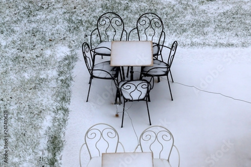 Outdoor furniture covered in snow. 