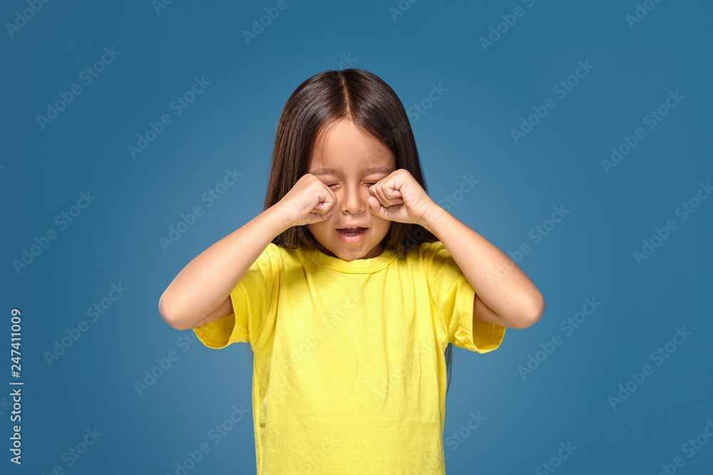 Sad offended little girl cries in yellow t-shirt Sad offended little girl cries in yellow t-shirt