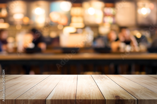 Wooden table with blur background of coffee shop.