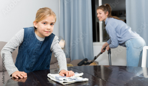 Girl helping mother with cleaning