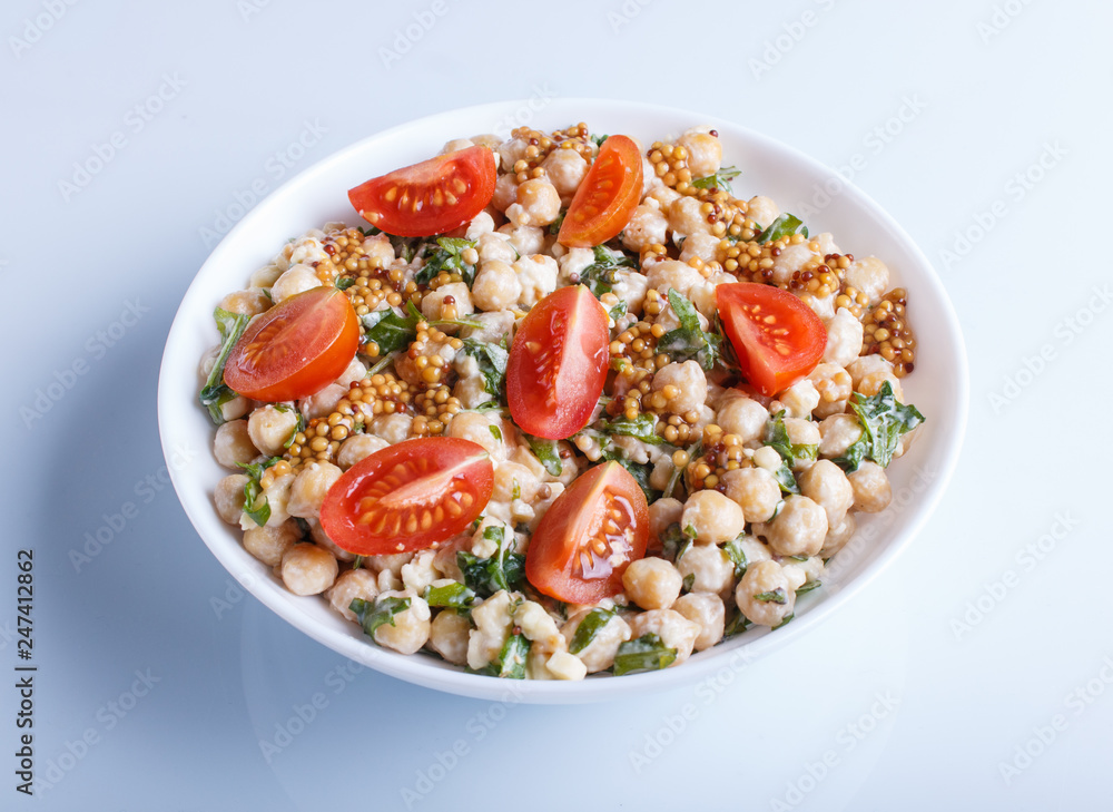 Vegetarian salad of boiled chickpeas, cheese, arugula, mustard and cherry tomatoes isolated on white background. Vegetarian salad of boiled chickpeas, cheese, arugula, mustard and cherry tomatoes isolated on white background.