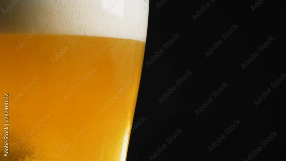 Close up of foamy beer being poured into glass Close up of foamy beer being poured into glass